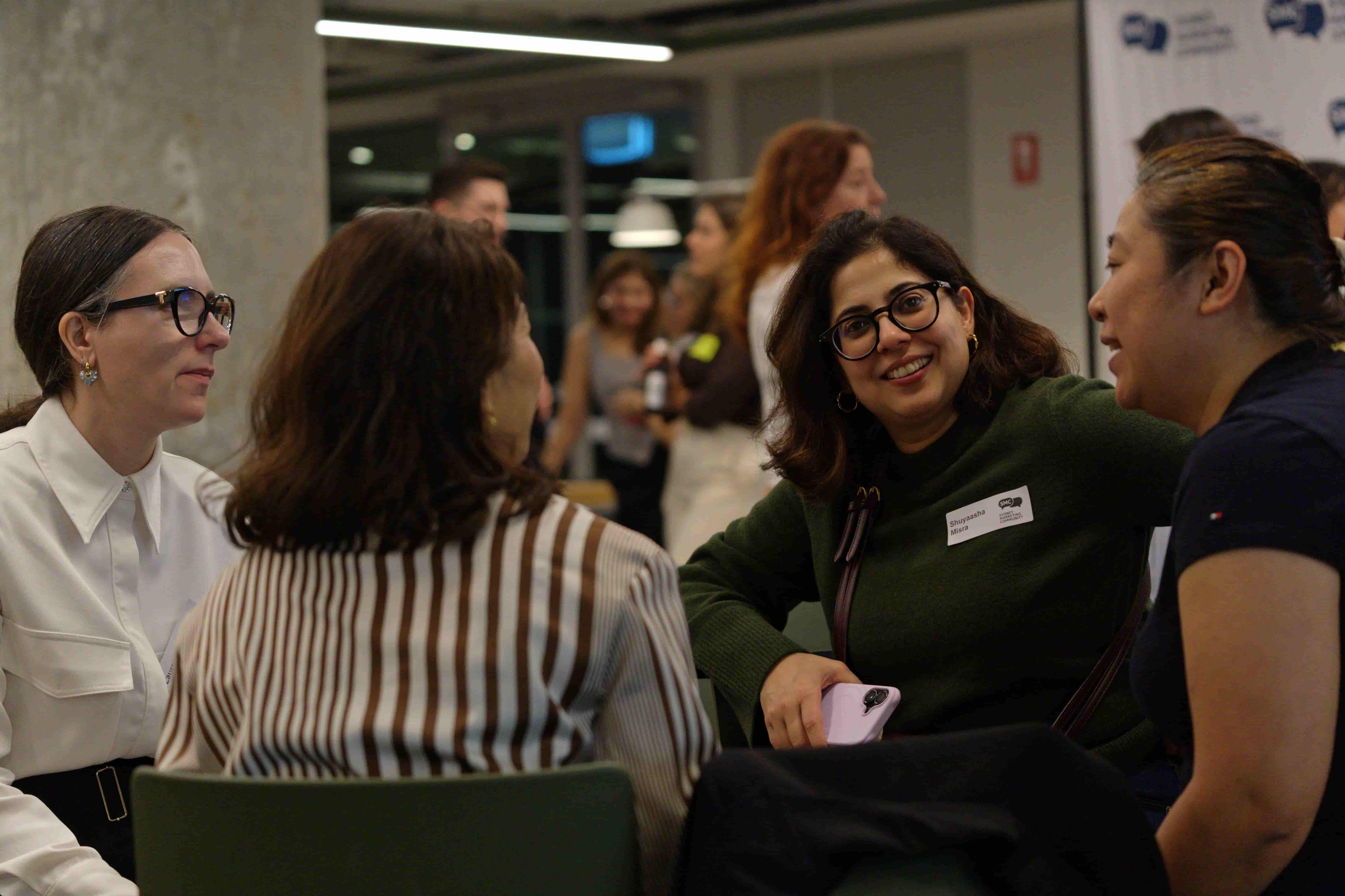 Several people talking, one person smiling at the camera