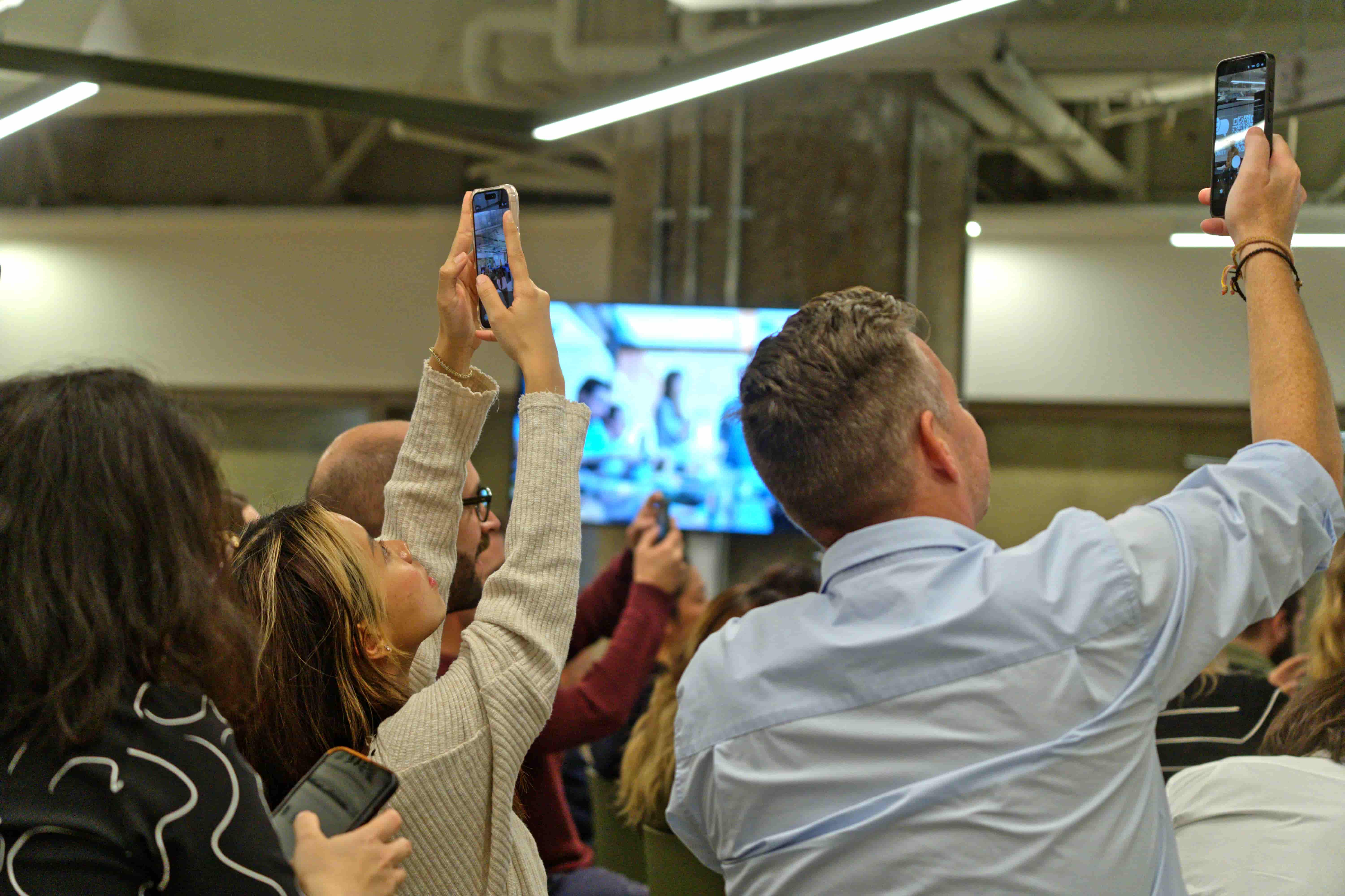 People holding up their phones to take a photo of 