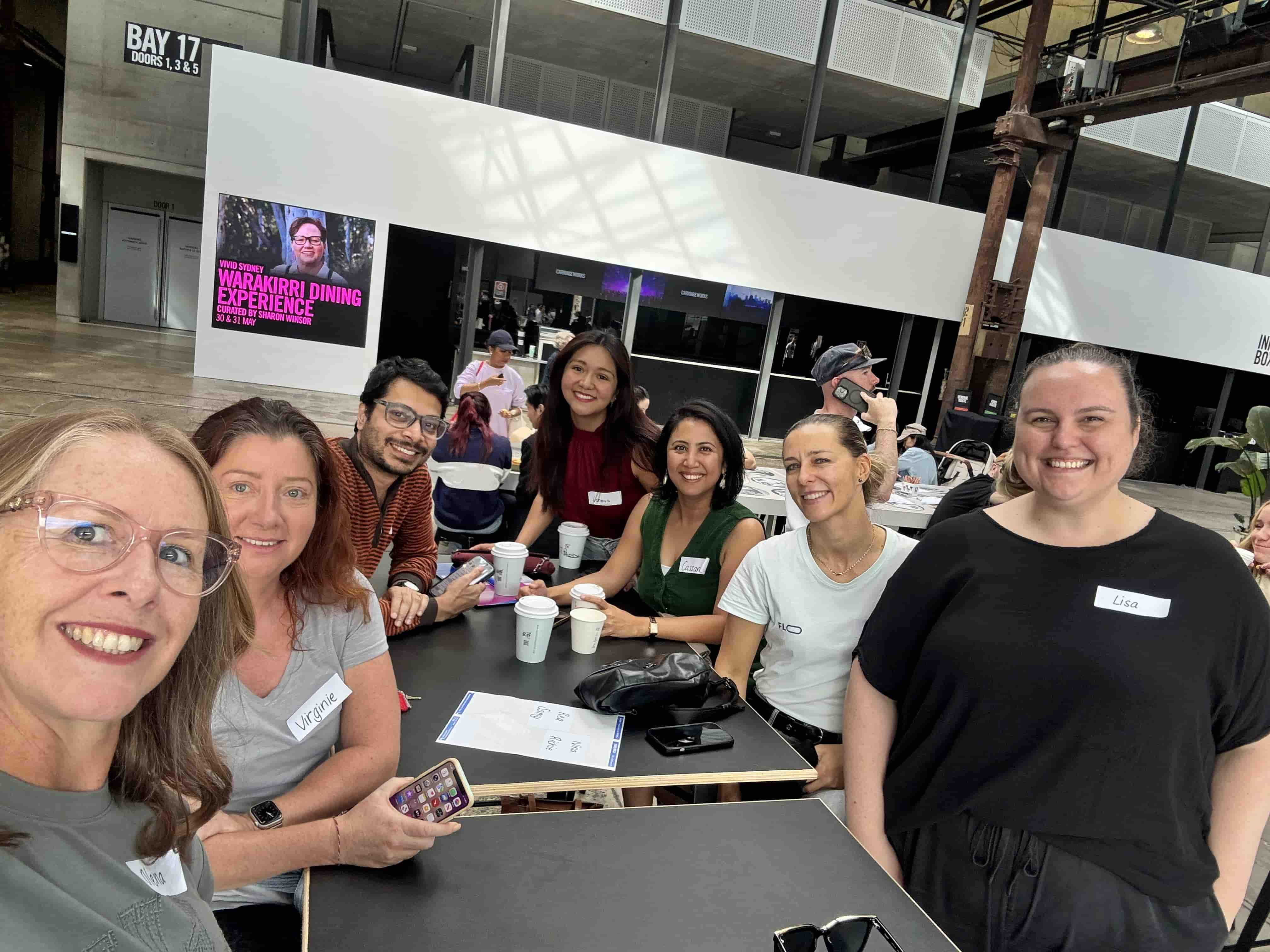 A selfie with 7 people stading at a table, smiling